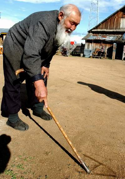 82岁的伊凡老人在地上写英文单词