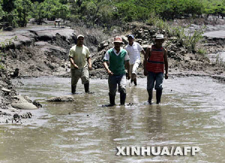 4月18日,人们在哥伦比亚乌伊拉火山附近的泥浆中行走。当日,乌伊拉火山大规模喷发,喷发造成的泥石流毁坏了许多桥梁、道路和房屋,当地约8000名居民被迫逃离家园。 新华社/法新