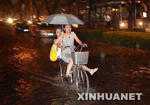 7月26日,两位西安市民冒雨赶路。 当晚8时许,西安地区突降暴雨,并伴有大风和雷电。暴雨造成西安城区部分路段短时积水,西安火车站多趟列车晚点,大批旅客滞留。 新华社记者 焦卫平 摄