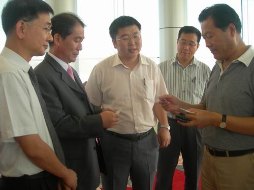 市长林秀山与韩国企业代表互赠名片.