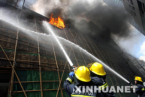 8月16日,上海消防人员在黄浦体育馆灭火。当天上午10点25分许,上海黄浦体育馆突发大火,三至四楼的竹制脚手架大面积燃烧,当时许多工人被困其中。10点30分,两辆消防车赶到现场,10分钟后火势得到控制。事故原因及具体损失情况还在调查中。 新华社发