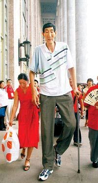 图片说明:"巨人"鲍喜顺无法走安检门,只能由工作人员手工安检