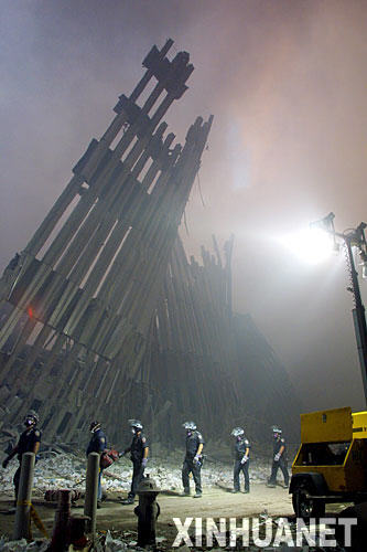 这是2001年9月11日,消防员从倒塌后的纽约世贸大厦废墟旁经过。