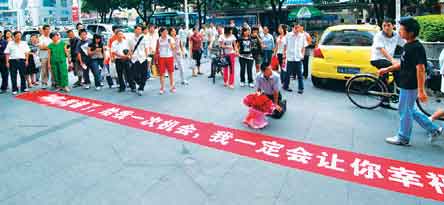 福建一男子闹市捧鲜花拉横幅下跪向女友道歉(图)