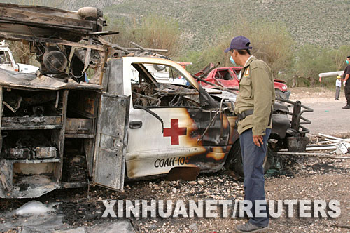 9月10日,在墨西哥北部的科阿韦拉州发生汽车相撞事故的现场,一名男子查看被炸毁的救护车。当地时间9日晚,一辆装载矿山炸药的集装箱货车与一辆面包车迎头相撞后发生爆炸。当地官员说,事故造成至少34人死亡。