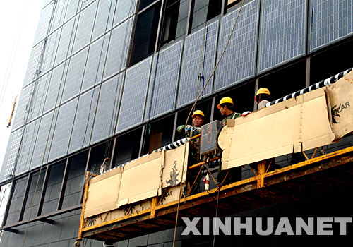 11月12日,工人正在保定电谷锦江国际酒店工地上安装光伏发电玻璃幕墙。 近日,一座利用太阳能可以并网发电的五星级酒店――保定电谷锦江国际酒店在河北保定市竣工。该酒店大厦的各个向阳立面都安装有光伏发电玻璃幕墙,在附属建筑屋顶、大堂顶部的玻璃采光区,也都装有光伏发电组件。所有位置安装的光伏发电组件,都有先进的数据采集系统,记录并显示太阳能发电系统即时发电量、总发电量及太阳能辐照度,风速等参数。这家酒店的建成为国内新能源行业进行太阳能设备与大体量建筑的工程融合提供了实践经验。