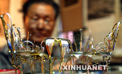 11月14日,张焕林正在用废旧易拉罐制作宫廷桌椅工艺品。