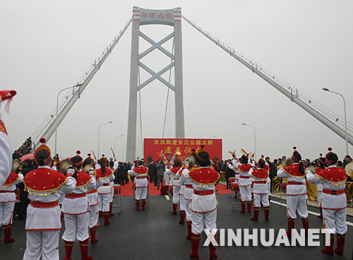 12月26日,武汉阳逻长江大桥通车仪式正在举行。当日,武汉市第5座长江大桥――阳逻长江大桥正式建成通车,全线贯通武汉长达188公里的公路外环线,至此,国家“五纵七横”国道主干线在武汉全面实现互通。全长10公里的阳逻长江大桥,是“十一五”期间国家和湖北省、武汉市重点工程建设项目,是京珠、沪蓉等国道主干线武汉绕城公路的重要组成部分和控制性工程,主桥及引桥桥面净宽33米,按双向6车道、全封闭、全立交高速公路特大桥标准设计建设,总投资约20亿元,为一跨过江悬索桥型,主跨1280米,是世界第八大悬索桥,大桥南锚碇基础工程被誉为“神州第一锚”。 新华社记者熊金超摄