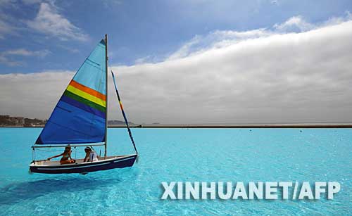 1月28日,在智利首都圣地亚哥以西95公里处的阿尔加罗沃,游客乘小船“漂游”在世界最大的游泳池内。这个巨型游泳池建在阿尔加罗沃一个海滨度假村内,面积为8公顷,储水量多达25万立方米,已经被收入吉尼斯世界纪录。