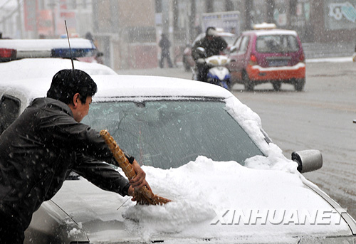 4月21日,宁夏固原市一位市民在清扫汽车上的积雪。受新疆东移较强冷空气影响,4月20日开始,宁夏迎来大风强降温天气过程,位于宁夏南部山区的固原市迎来了雨雪天气。 新华社记者 曹健 摄