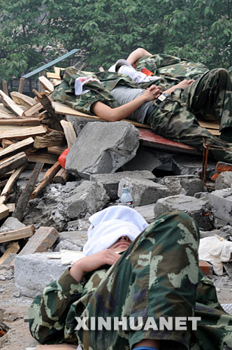5月17日,救援人员在四川省什邡市救灾现场抓紧时间休息。 汶川地震发生后,救援人员奔赴各个灾区,争分夺秒、夜以继日地在搜救现场奋战。为了尽量多地救出掩埋在废墟下的生还者,他们与时间赛跑,利用有限的空闲稍事休息,补充体力。