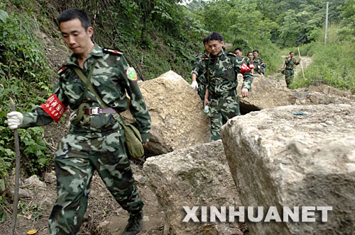 6月2日,来自成都印钞公司的民兵在都江堰市赵公山附近搜寻5月31日失事的直升机。 新华社记者李健摄