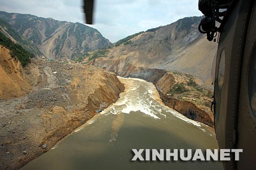 这是6月10日航拍的泄流渠入口。 目前,唐家山堰塞湖大坝基本稳定,洪水把导流槽冲刷成一个深达几十米的峡谷。导流槽泄洪的全过程在救灾人员的控制之中,不会给下游造成灾害。截至记者发稿时,水流量已经降到3000立方米/秒,整个泄洪过程比预想的情况好。在大坝抢险的解放军官兵大部分已经撤离。 新华社记者李刚摄
