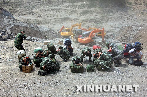 6月10日,抢险官兵准备搭机撤离。 目前,唐家山堰塞湖大坝基本稳定,洪水把导流槽冲刷成一个深达几十米的峡谷。导流槽泄洪的全过程在救灾人员的控制之中,不会给下游造成灾害。截至记者发稿时,水流量已经降到3000立方米/秒,整个泄洪过程比预想的情况好。在大坝抢险的解放军官兵大部分已经撤离。 新华社记者李刚摄