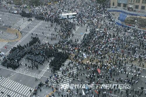 6月8日,韩国防暴警察在首尔街头阻挡准备前往总统府的抗议民众。虽然韩国总统李明博7日晚与美国总统布什就牛肉贸易问题通电话,但韩国民众反对恢复进口美国牛肉的示威游行仍未停止。 新华社/路透