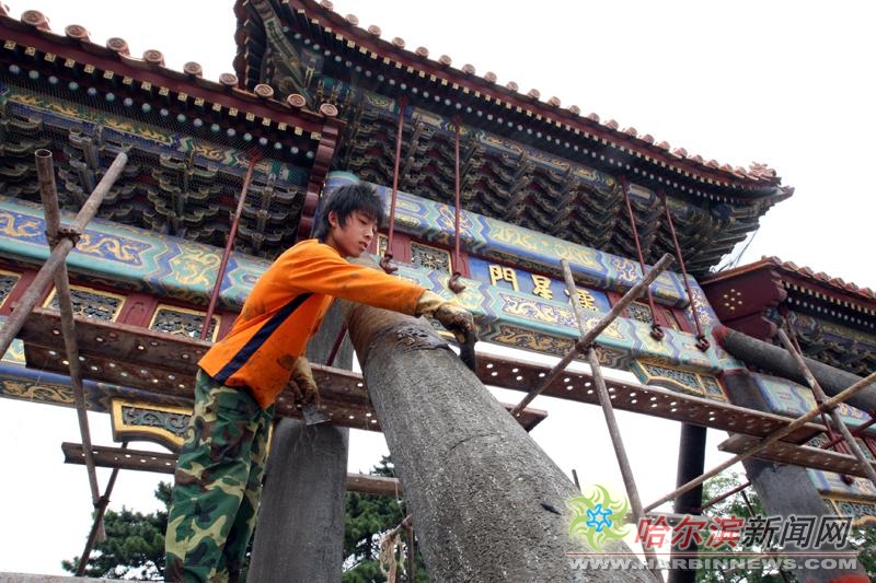 昨日,哈尔滨文庙魁星门修缮工作全面启动,施工人员正在往柱子上涂抹