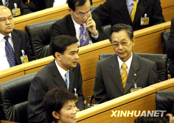 12月15日,在泰国首都曼谷的国会大厦内,泰国民主党主席阿披实(左)当选总理后与泰国前总理川·立派(右)交谈。阿披实当日在国会下议院总理选举特别会议上以235票获得多数议员支持,当选泰国第27位总理。