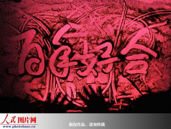 2009年8月16日,何衡生正在创作“沙画”。 版权作品,请勿转载。