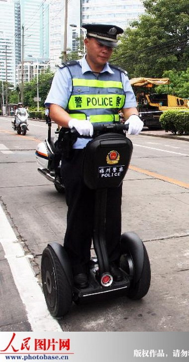 2009年9月14日,一名福州警察在全运会火炬传递过程中使用“赛格威”单兵警用巡逻车,如同脚下踩着两个“风火轮”。 版权作品,请勿转载。