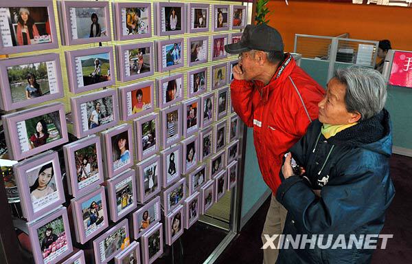 12月16日,两位老人在“爱情超市”内为孙子挑选对象。