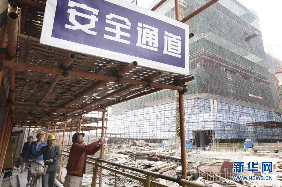 11月19日,上海徐汇区一在建工地的安全员在检查工地安全通道.