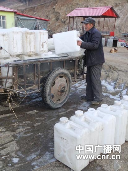 清晨赶牛车前往取水点取水的老人