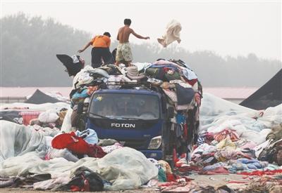 北京:商贩从废品站回收旧衣服 10元一件卖向工