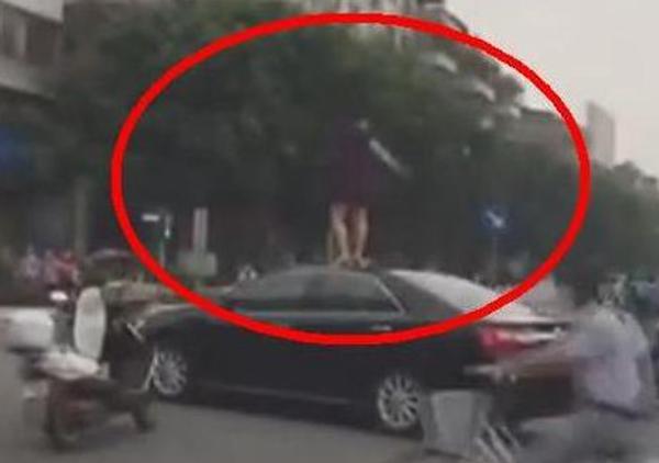  大妈 闯红灯险被撞 爬上 对方 车顶跳舞  网友无语