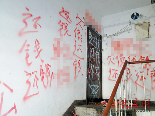 记者看到,从4楼半到5楼的墙体上写满大红字,上有"欠债还钱"和骂人