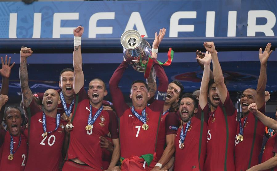 7月10日,葡萄牙队球员克·罗纳尔多(中)在颁奖仪式上高举奖杯