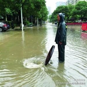 最暖心的路标!海口暴雨冲走井盖 老人冒雨坚