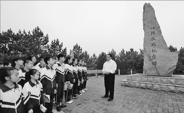 江桥抗战纪念碑前,江桥抗战纪念馆馆长刘国忠正在为江桥镇中心校的