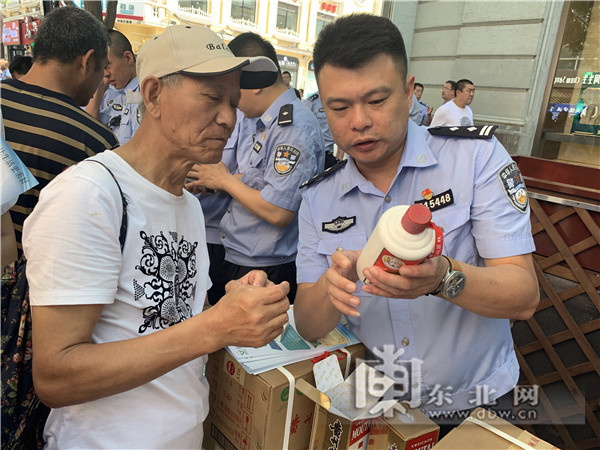 民警告诉群众假酒辨别方式.东北网记者 赵红星 摄