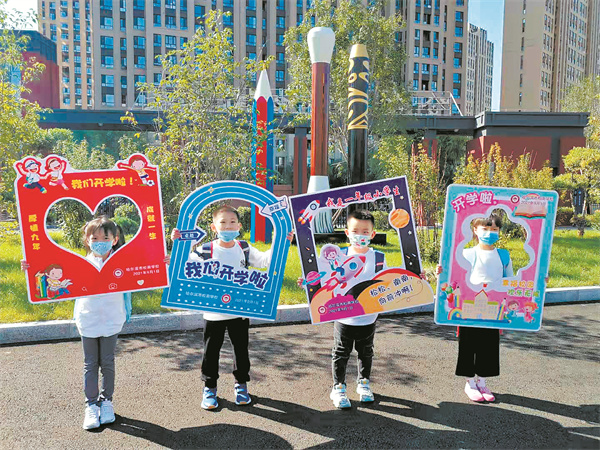 新生手持卡通板合影.本报记者周雪莉摄